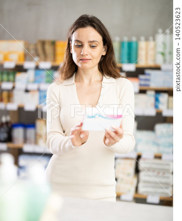 Woman choose pills in pharmacy Woman choose pills in pharmacy 140523623