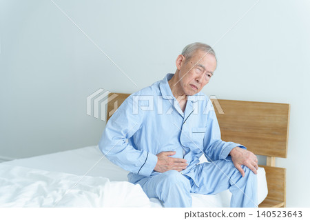 An elderly man clutching his stomach. An elderly man clutching his stomach. 140523643