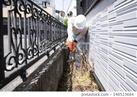 Workers spraying herbicide on private property. 140523684