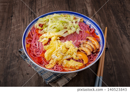 Vibrant purple sweet potato noodles served in a rich tomato sauce, topped with eggs and fresh lettuce. 140523843