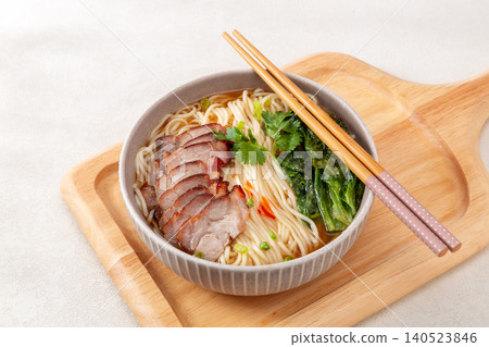 Cantonese style noodle soup topped with sweet savory sliced barbecue pork (Char Siu) and greens. Cantonese style noodle soup topped with sweet savory sliced barbecue pork (Char Siu) and greens. 140523846