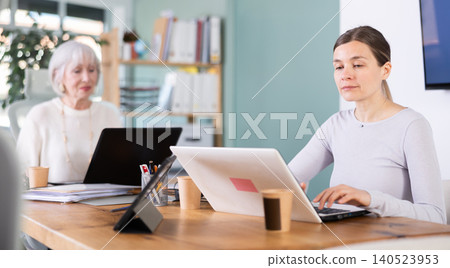 Elderly and adult women working in office 140523953
