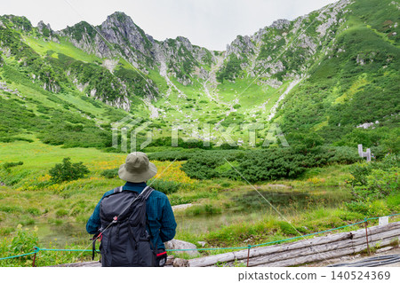 The spectacular view of Senjojiki Cirque from Ken-ga-ike Pond and the hikers 140524369