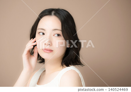 A beauty portrait featuring a woman with an ennui expression gazing against a brown background, highlighting her concerns and worries about her skin. A beauty portrait featuring a woman with an ennui expression gazing against a brown background, highlighting her concerns and worries about her skin. 140524469