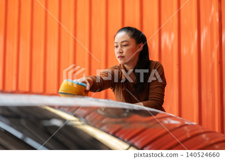 woman washing car with sponge and foam in a self-service car wash station woman washing car with sponge and foam in a self-service car wash station 140524660