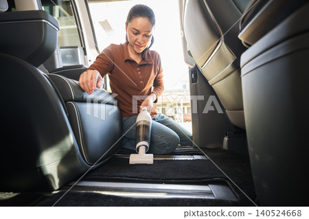 woman using portable handheld vacuum cleaner to cleaning the floor mat of her luxury car woman using portable handheld vacuum cleaner to cleaning the floor mat of her luxury car 140524668