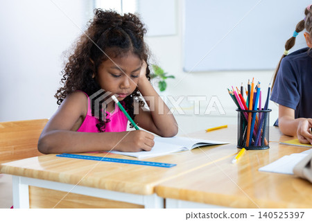 girl is studying and doing her homework in the classroom. 140525397