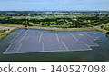 [Aerial view] Floating mega solar power plant on a reservoir and the sprawling cityscape (Renewable energy, SDGs) 140527098