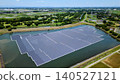 [Aerial view] Floating mega solar power plant on a reservoir and lush green cityscape (Saitama Prefecture, Renewable Energy, SDGs) 140527121