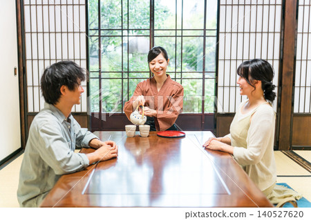 A female inn staff member, Nakai, pours tea in a guest room at a hot spring inn A female inn staff member, Nakai, pours tea in a guest room at a hot spring inn 140527620