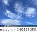 A wall reflecting the blue sky, clouds, and sunlight. 140528055