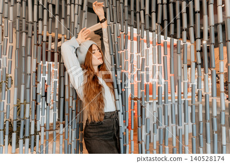 Woman Meditation Beret standing behind a beaded curtain with her eyes closed and arms raised in a serene indoor setting 140528174