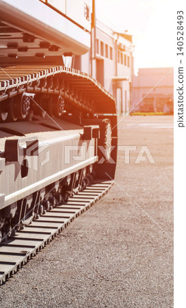 Close up view of heavy machinery track system on gravel ground outdoor during bright day, industrial construction equipment detail for earthmoving and digging work, vertical photo 140528493