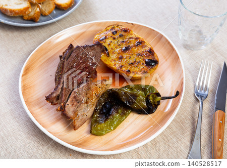 Grilled beef with roasted potatoes and bell peppers on plate 140528517