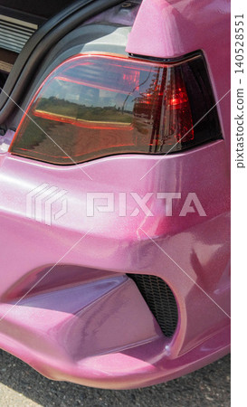 Vibrant pink custom painted car showcasing detailed rear light and bumper design, highlighting craftsmanship of tuning and personalization of vehicle, vertical photo format capturing unique automotive Vibrant pink custom painted car showcasing detailed rear light and bumper design, highlighting craftsmanship of tuning and personalization of vehicle, vertical photo format capturing unique automotive 140528551