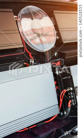 Car audio system installation with multiple amplifiers and clear power capacitor, showcasing intricate wiring for enhanced sound quality and vehicle tuning. Car audio system installation with multiple amplifiers and clear power capacitor, showcasing intricate wiring for enhanced sound quality and vehicle tuning. 140528555