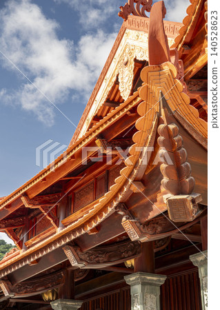 Extreme close-up of richly detailed golden and red carved wooden temple eaves at the Ho Chi Minh memorial in Vietnam. Exceptional traditional Vietnamese artisanship. 140528623
