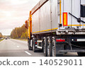 Large semi truck trailer transportation on asphalt highway road at sunset sky driving cargo delivery logistics freight industry commercial vehicle moving goods 140529011