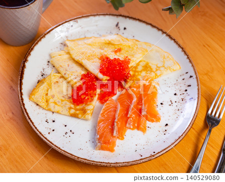 Thin pancakes with caviar and salmon on a plate Thin pancakes with caviar and salmon on a plate 140529080