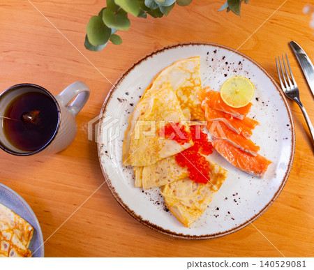 Thin pancakes with caviar and salmon on a plate 140529081
