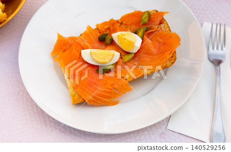 Toast with salmon, egg, and sliced pickled cucumber 140529256