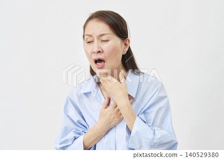A woman suffering from holding her throat on a white background A woman suffering from holding her throat on a white background 140529380