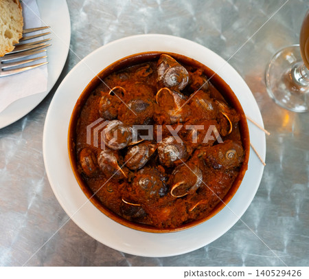 Delicious baked snails in bowl with salsa sauce Delicious baked snails in bowl with salsa sauce 140529426