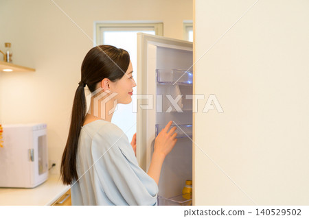 A Japanese woman who opens a refrigerator A Japanese woman who opens a refrigerator 140529502