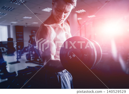Handsome muscular man working out with dumbbells. Handsome muscular man working out with dumbbells. 140529529