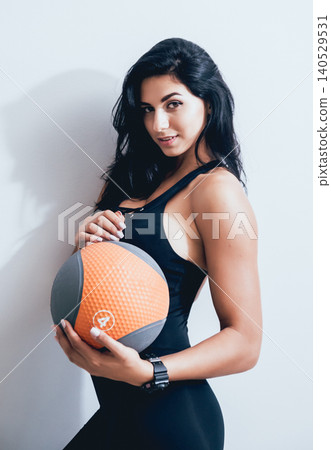 Athletic young woman training with medball at gray background. Crossfit center. Athletic young woman training with medball at gray background. Crossfit center. 140529531