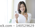 Women enjoying online shopping on their smartphones: Cashless payments and online shopping 140529629