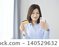 A woman using a credit card and paying with her smartphone – an image of a cashless society. 140529632