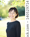 A smiling female dancer in her 40s in an autumn park. 140529714