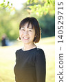 A smiling female dancer in her 40s in an autumn park. 140529715