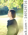 A female dancer in her 40s standing in an autumn park. 140529716