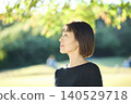 A female dancer in her 40s standing in an autumn park. 140529718