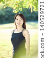 A female dancer in her twenties standing in an autumn park. 140529721