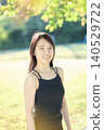 A smiling female dancer in her 20s in an autumn park. 140529722