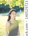 A female dancer in her twenties standing in an autumn park. 140529723