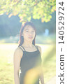 A female dancer in her twenties standing in an autumn park. 140529724