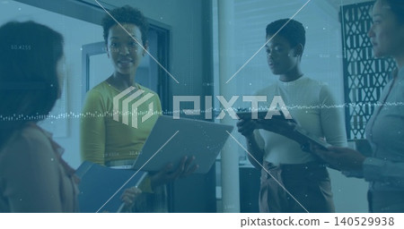 Holding laptop and blue folder, woman in chartreuse top leading huddle at office with data overlay Holding laptop and blue folder, woman in chartreuse top leading huddle at office with data overlay 140529938