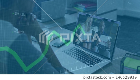 Showing laptop at desk two hosts light blouse jacket holding chart; attendee watching, green graph Showing laptop at desk two hosts light blouse jacket holding chart; attendee watching, green graph 140529939