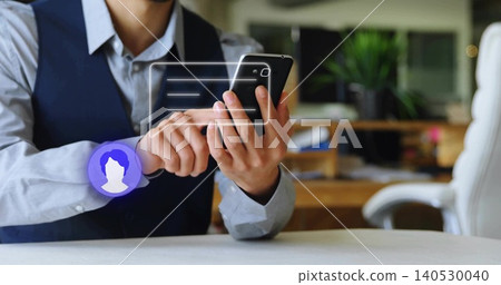 Holding man in blue shirt and dark vest, scrolling smartphone at office desk, showing chat overlay Holding man in blue shirt and dark vest, scrolling smartphone at office desk, showing chat overlay 140530040