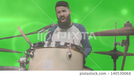 Singing bearded drummer playing drum kit in green screen studio, wearing raglan shirt with mic Singing bearded drummer playing drum kit in green screen studio, wearing raglan shirt with mic 140530068