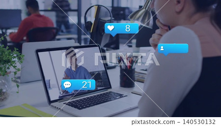 Watching woman at office desk resting chin, viewing laptop showing Korean in blue top, with bubbles Watching woman at office desk resting chin, viewing laptop showing Korean in blue top, with bubbles 140530132