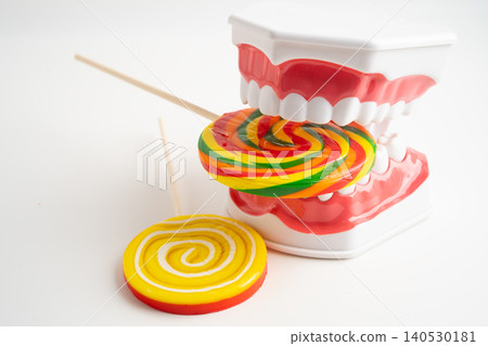 Tooth decay model with colorful candy sweet food on white background with copy space. Tooth decay model with colorful candy sweet food on white background with copy space. 140530181