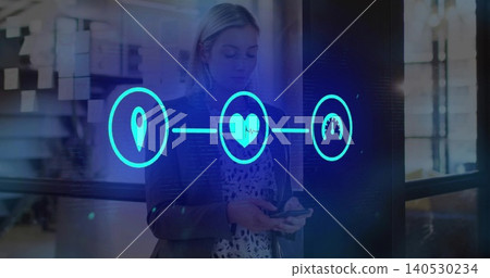 Holding smartphone, woman in dark blazer patterned blouse viewing holographic icons in office 140530234