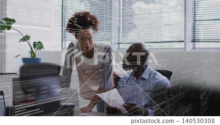 Discussing man in collared shirt holding paper with woman in blouse at office, monitor overlays Discussing man in collared shirt holding paper with woman in blouse at office, monitor overlays 140530308