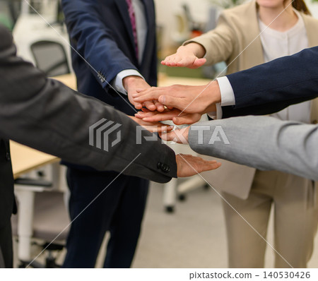 Business team shows unity by joining hands. Business team shows unity by joining hands. 140530426