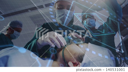 Performing surgical staff in green gowns manipulating airway mask and tube in operating room, HUD Performing surgical staff in green gowns manipulating airway mask and tube in operating room, HUD 140531001